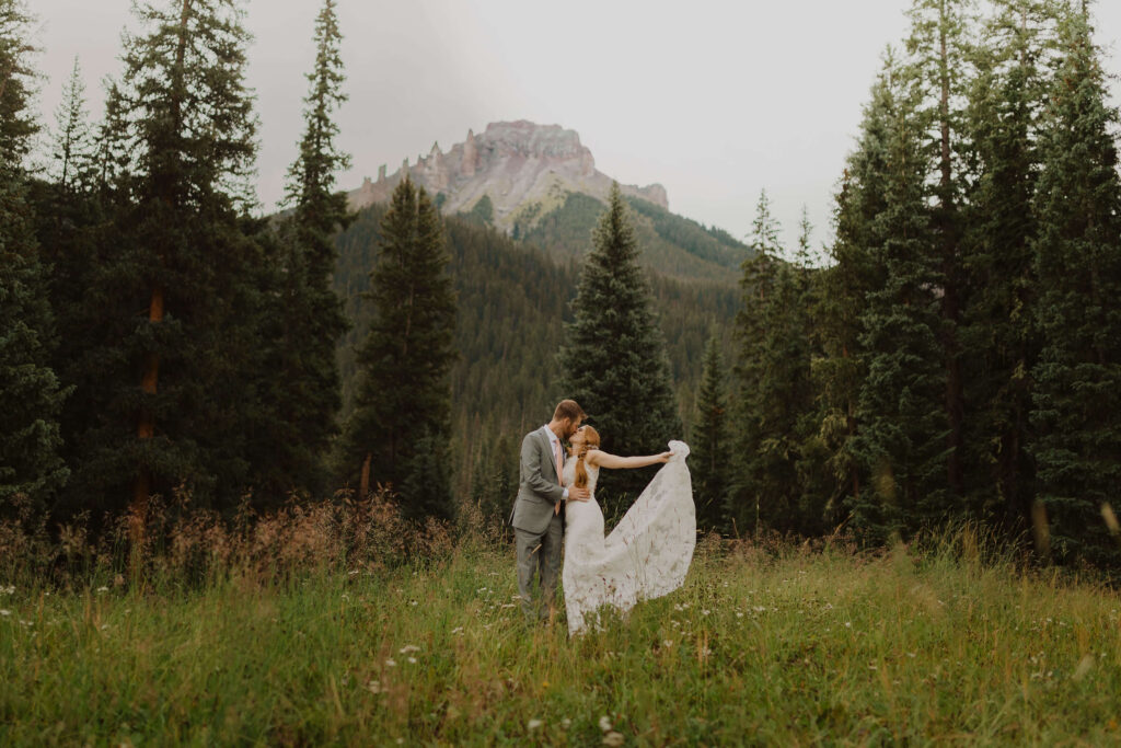 Bride and groom hugging surrounded by aspen trees and the San Juan Mountains