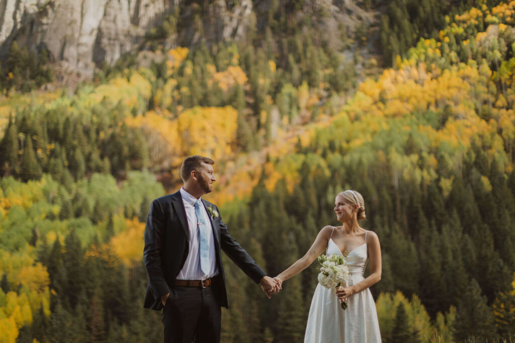 Bride and groom holding hands posing for San Juan Mountain elopement photos