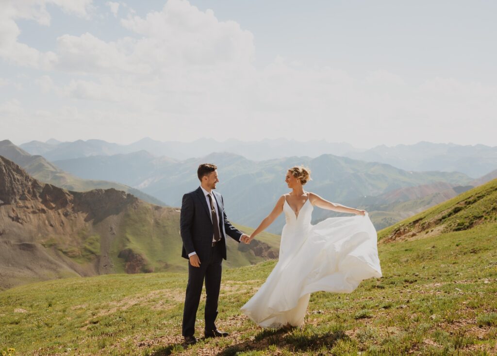 Bride and groom holding hands surrounded by San Juan Mountains