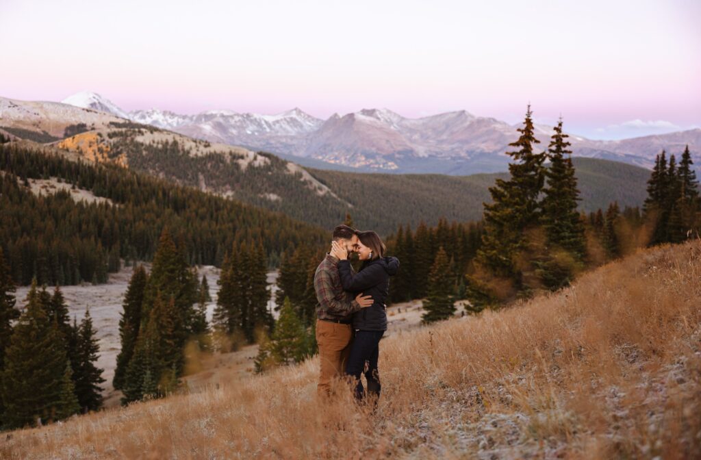 Couple posing in Breckenridge at Boreas pass surrounded by trees and mountains