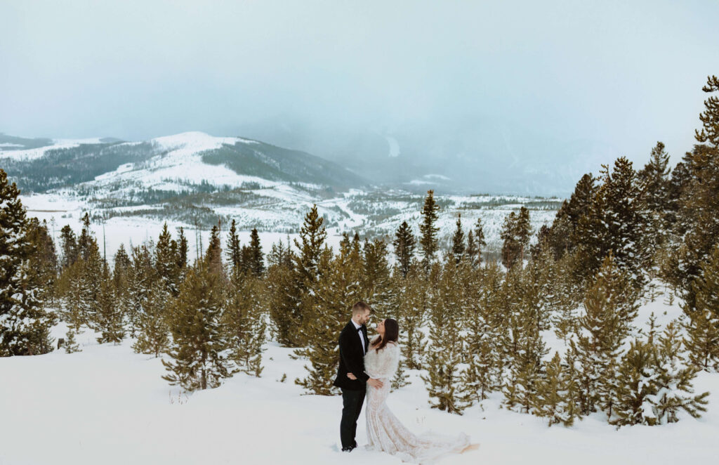 Couple posing in the snow at Sapphire Point Overlook for elopement ceremony