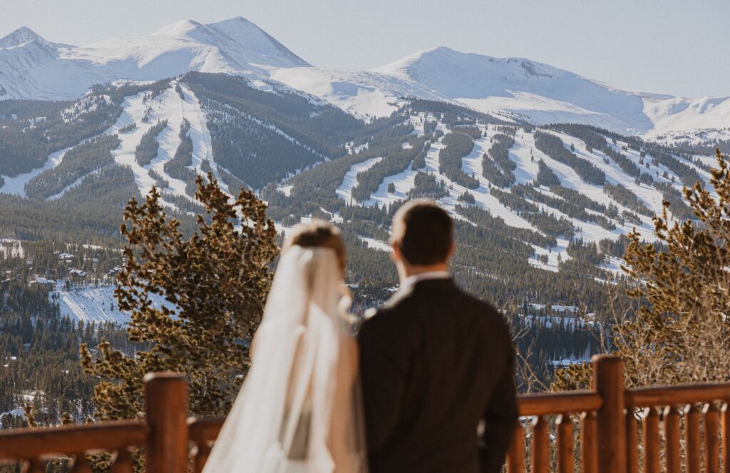 Bride and groom looking at mountain scenery with snow