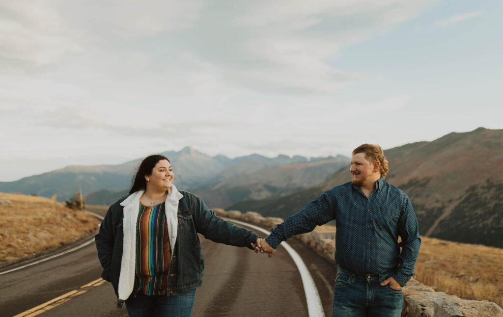 Couple holding hands posing for Rocky Mountain National Park engagement photos