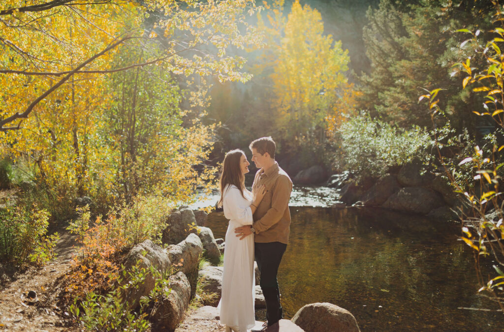 Couple hugging surrounded by trees for engagement photos at Rocky Mountain National Park