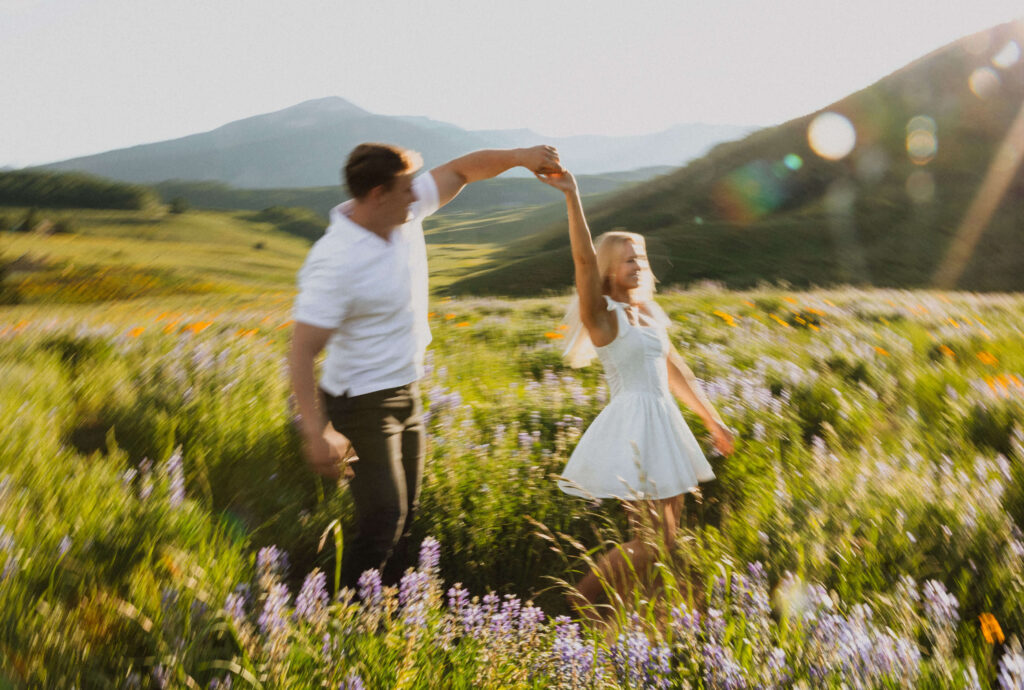 Couple dancing surrounded by wildflowers for proposal photos in Colorado