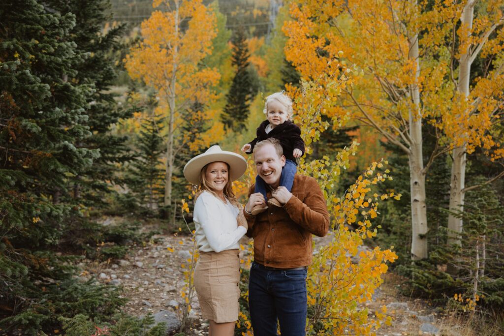 mom and dad with son posing for family photos near Denver