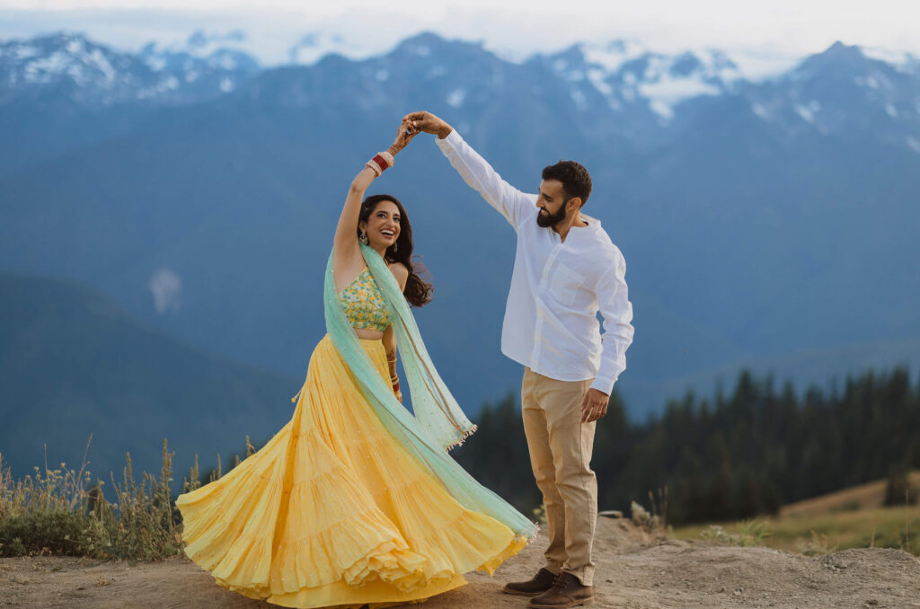 Bride and groom dancing in front of mountain scenery