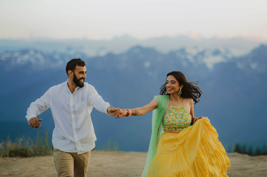 Bride and groom dancing in front of mountain scenery