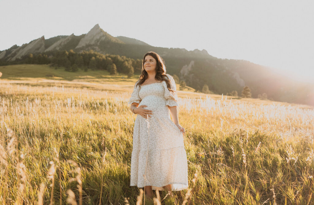 Pregnant mom posing for maternity photos backed by mountains