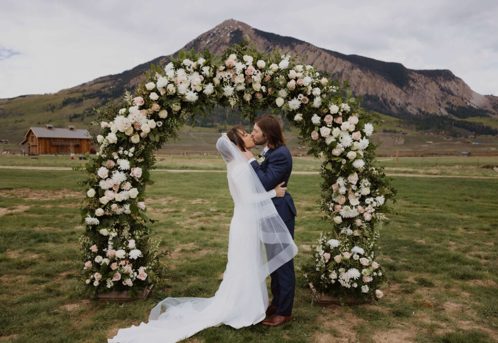 Bride and groom kissing at Town Ranch wedding venue in Crested Butte
