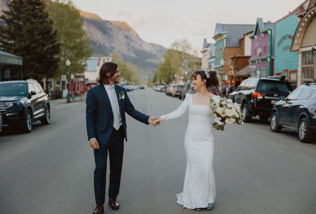 Bride and groom holding hands in downtown Crested Butte