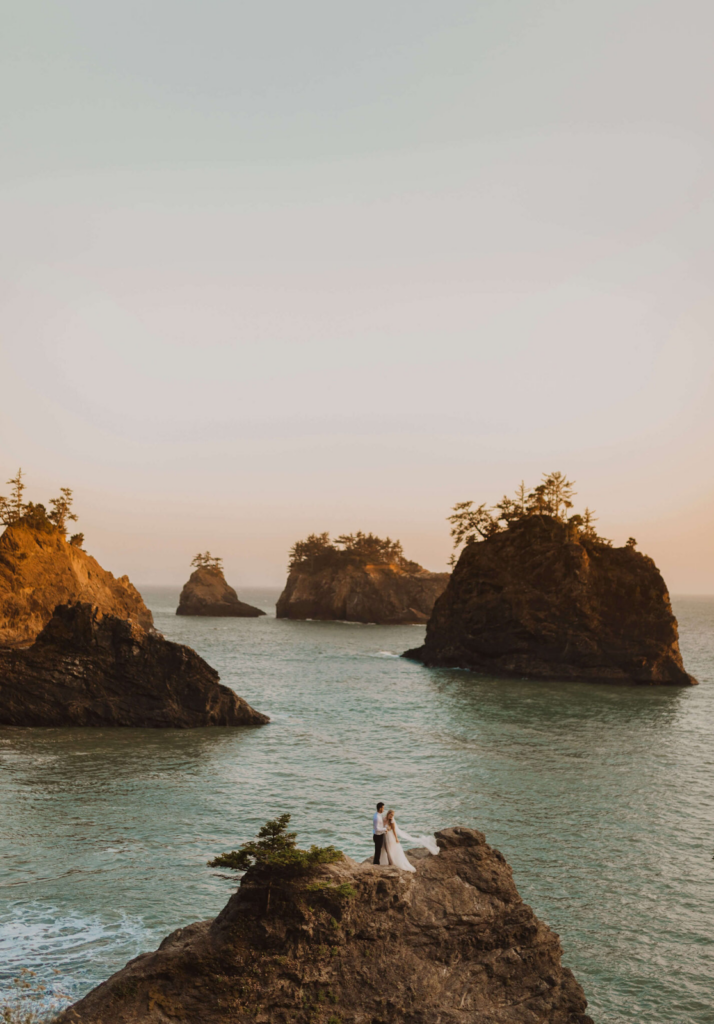 Bride and groom standing on rock surrounded by ocean for Washington State elopement