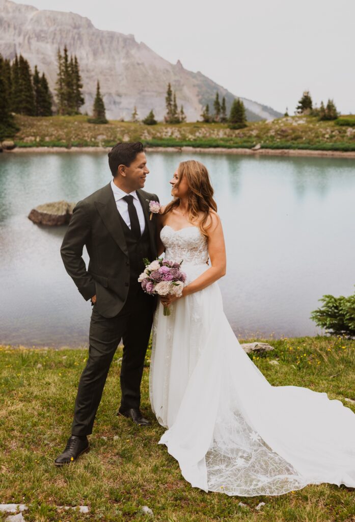 bride and groom posing in front of lake at Ouray wedding venue