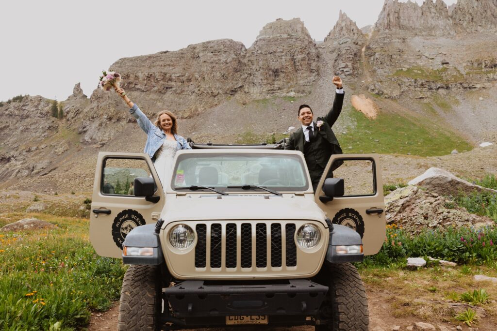 bride and groom posing in jeep in Ouray