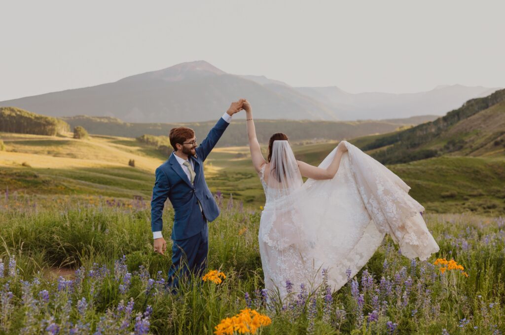 Bride and groom dancing surrounded by flowers and mountain scenery