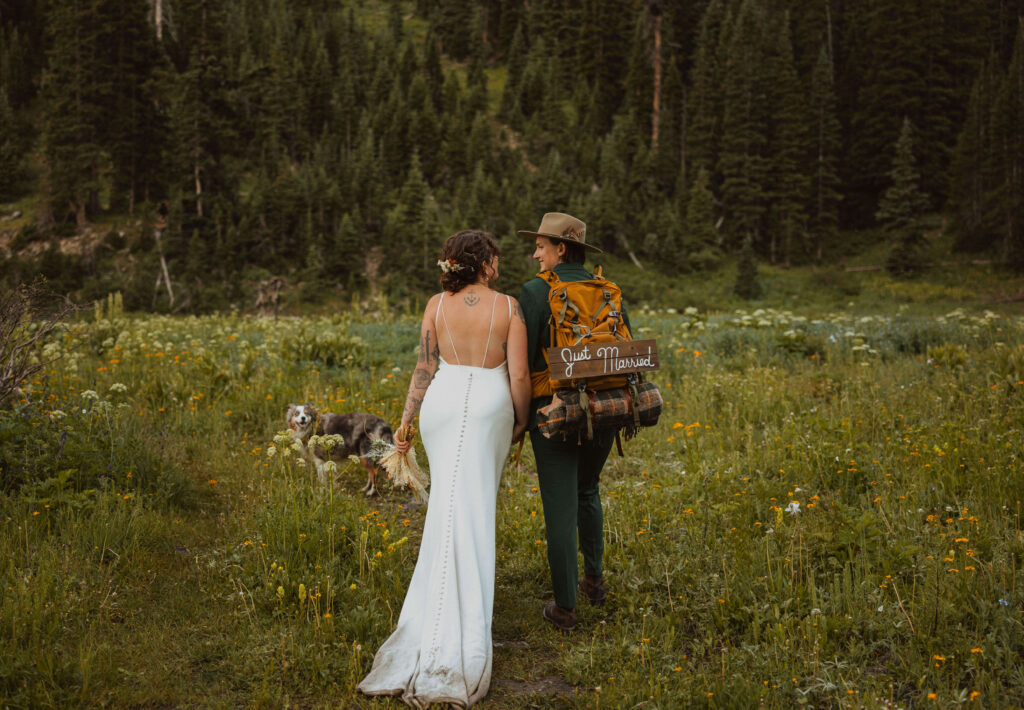 couple hiking on wedding day with dog