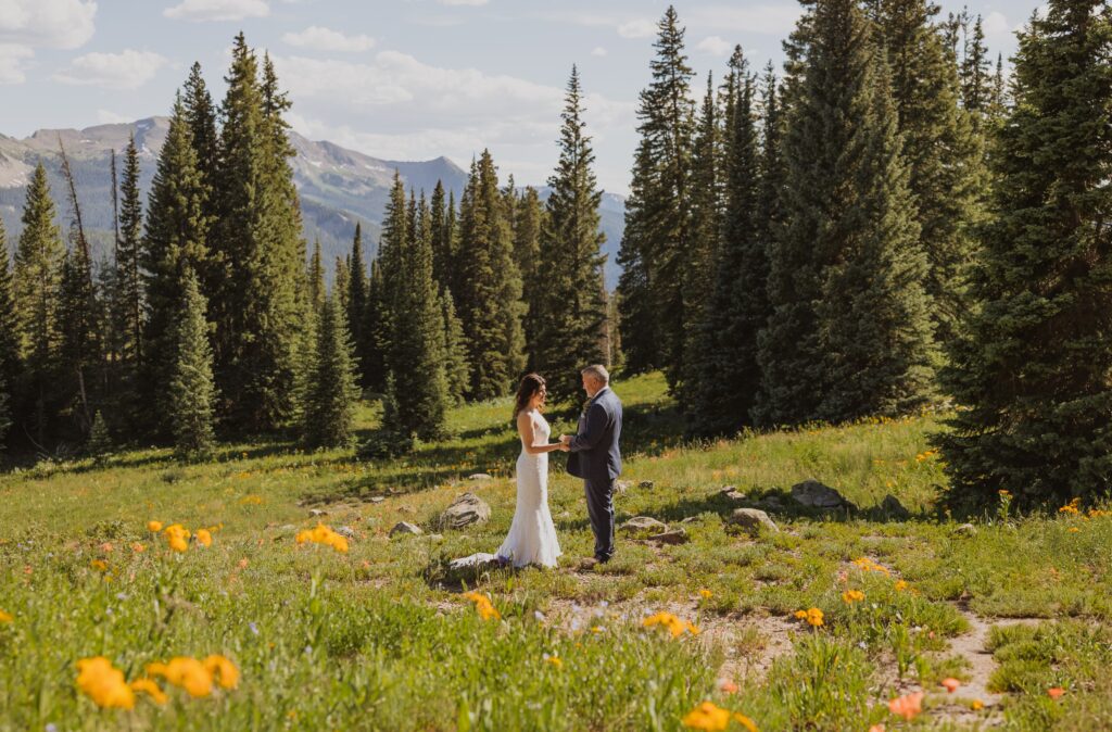 bride and groom exchanging vows surrounded by aspen trees in Ouray