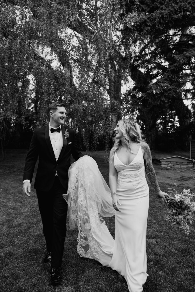 Black and white photo of bride and groom smiling at each other