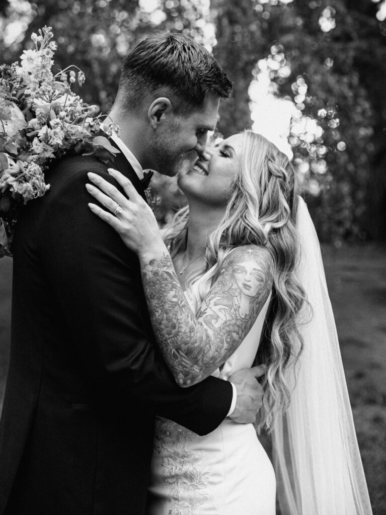 Black and white photo of bride and groom embracing and smiling at each other