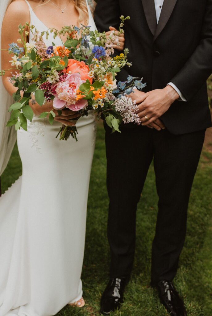 Bride holding flowers and standing next to groom