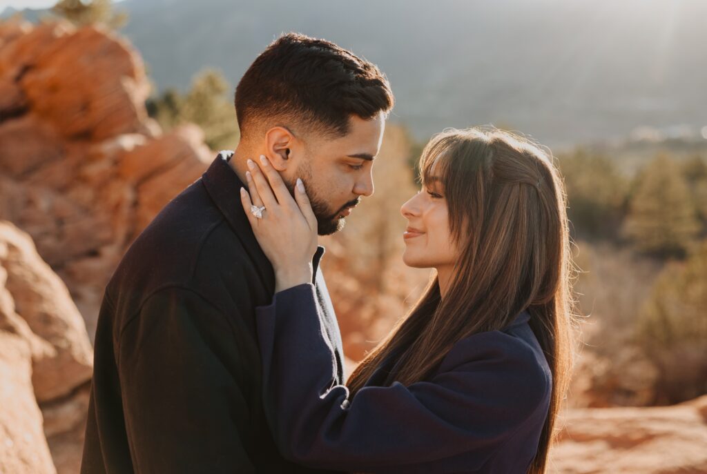 Couple looking at each other backed by red rock formations in Colorado Springs