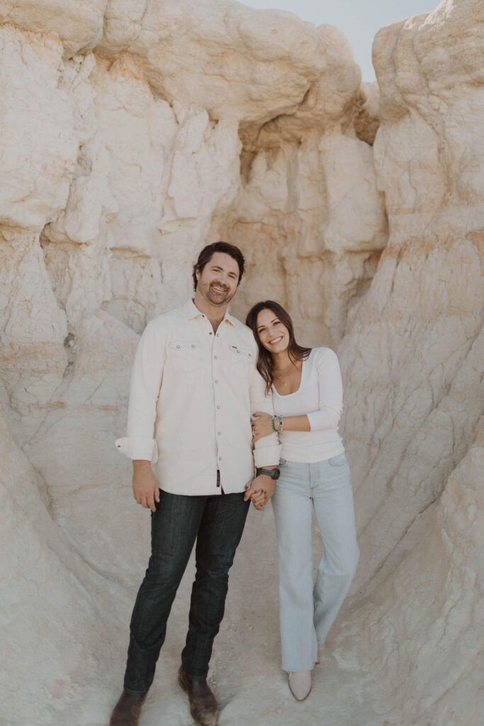 Couple smiling at camera posing for engagement photos in Colorado Springs