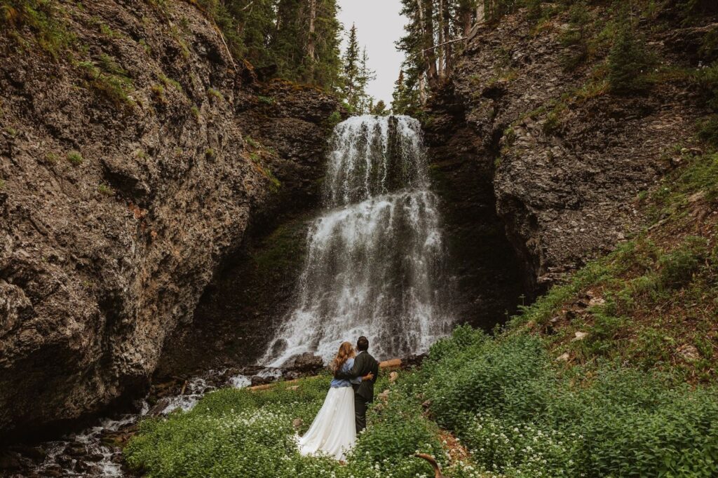 Bride and groom looking at waterfall