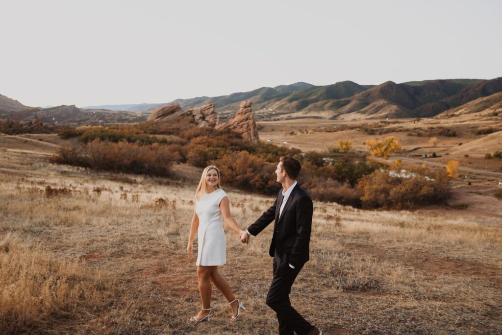 Couple looking at each other surrounded by mountain peaks and red rocks