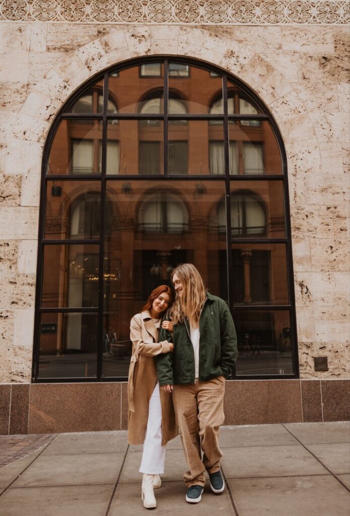 Couple posing for photo in front of building in Downtown Denver