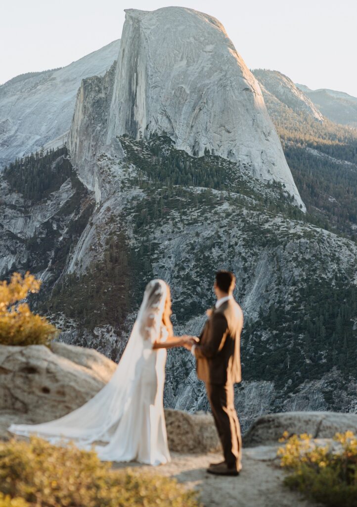 Bride and groom looking at a mountain at Yosemite National Park