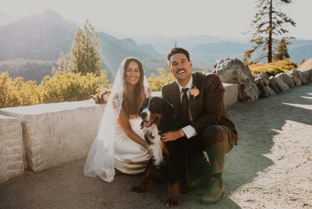 Bride and groom smiling with dog at Yosemite National Park wedding
