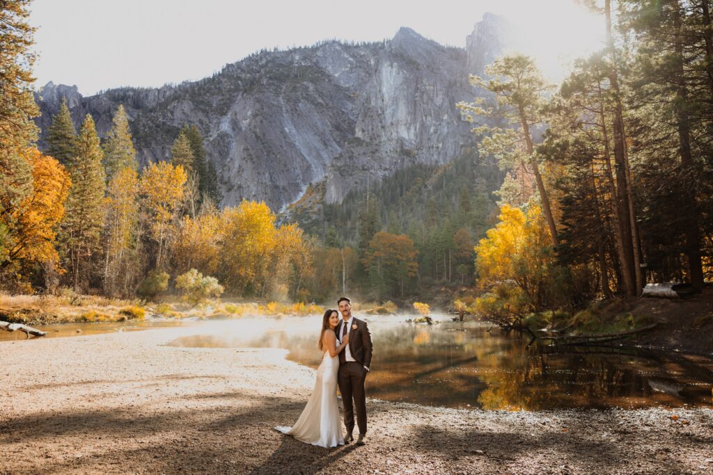Bride and groom posing at Yosemite National Park surrounded by golden trees