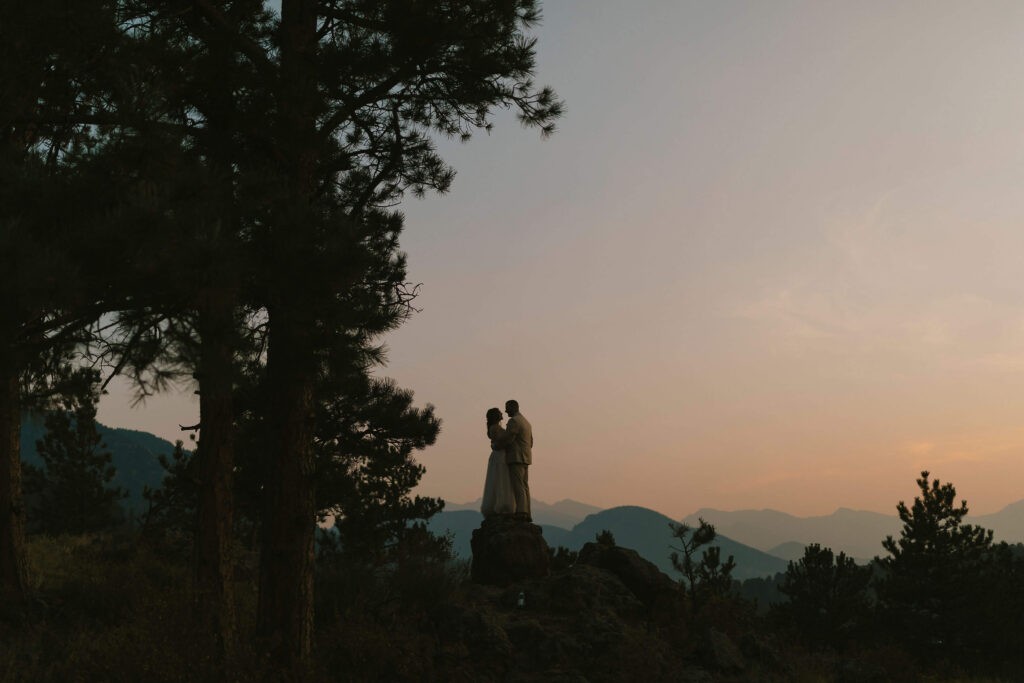 Bride and groom looking at sunset over the mountains at Rocky Mountain National Park