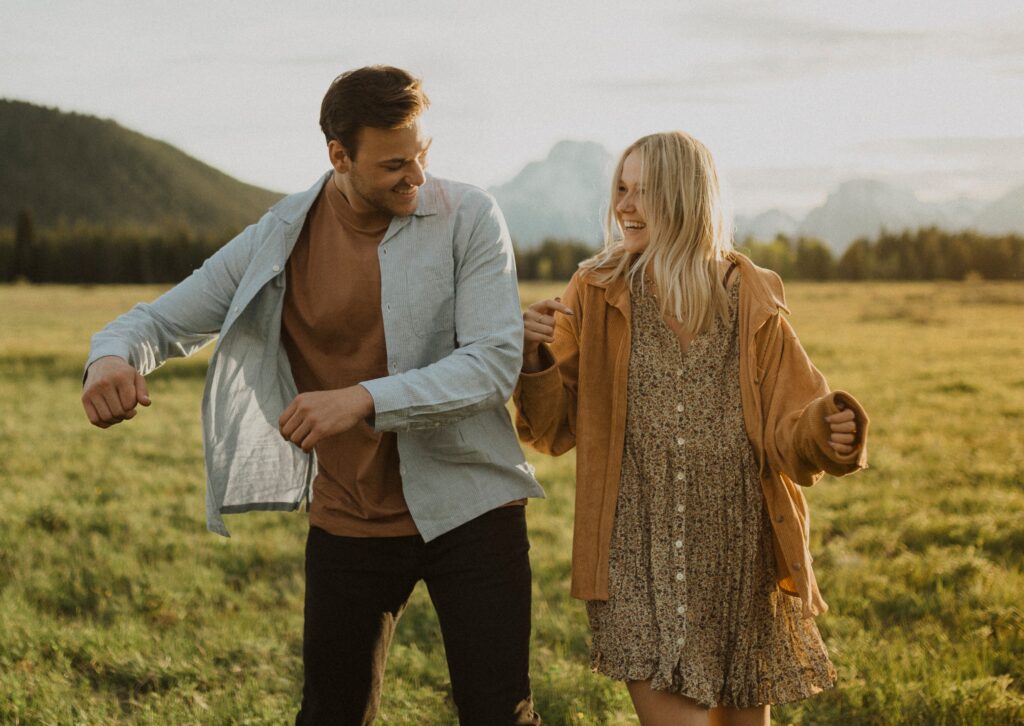 Couple smiling at each other surrounded by greenery at Grand Teton National Park