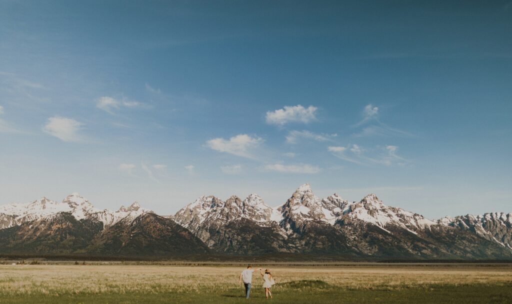 Couple walking towards mountain at Grand Teton National Park