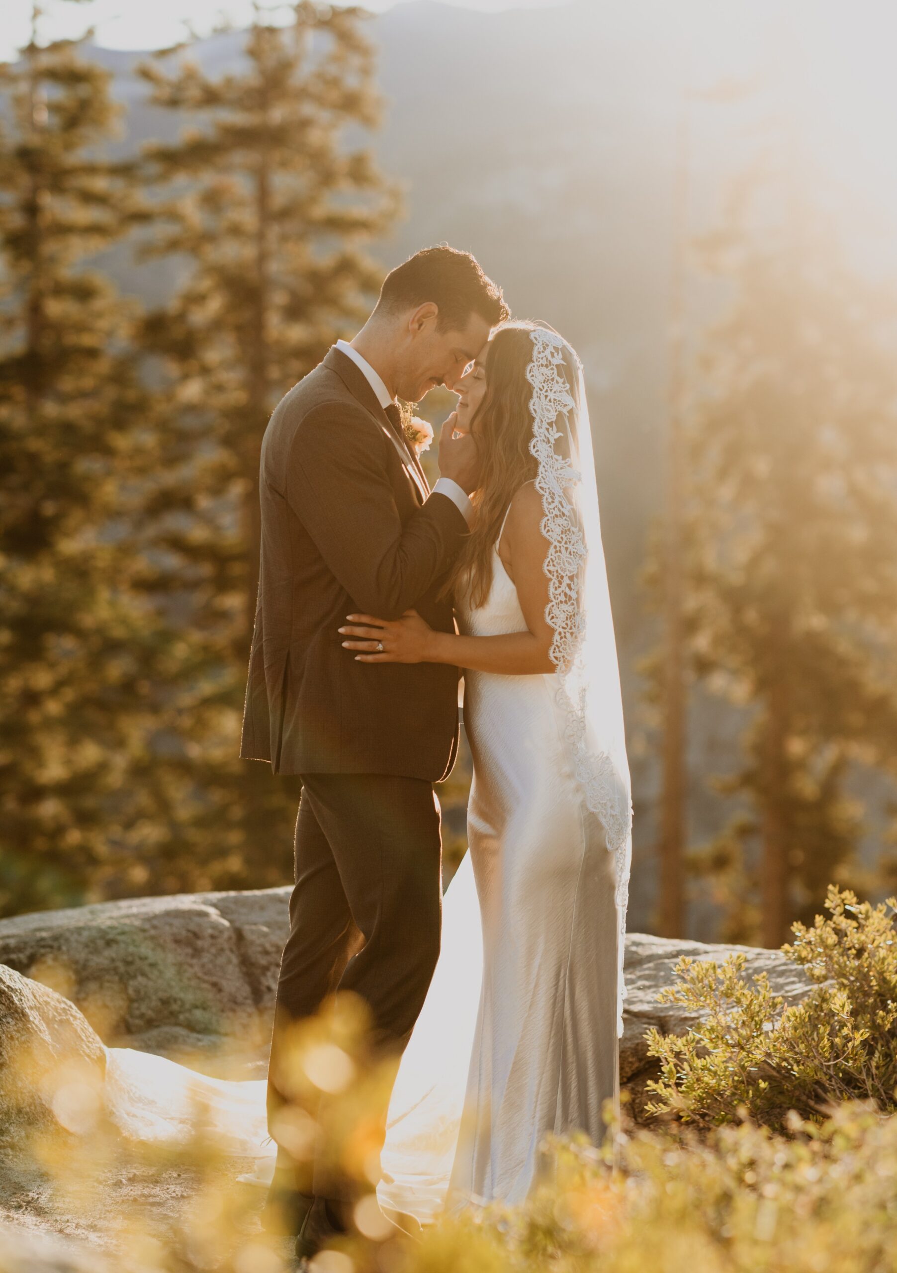 Bride and groom surrounded by trees posing for elopement photo