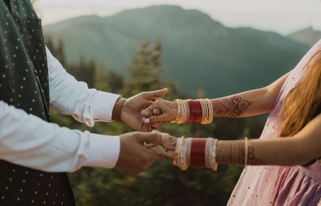 Couple holding hands with mountains in the background