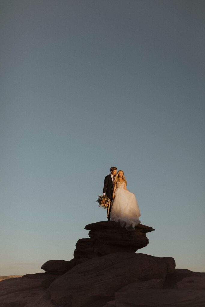 Couple standing on rock formation for Utah elopement photo