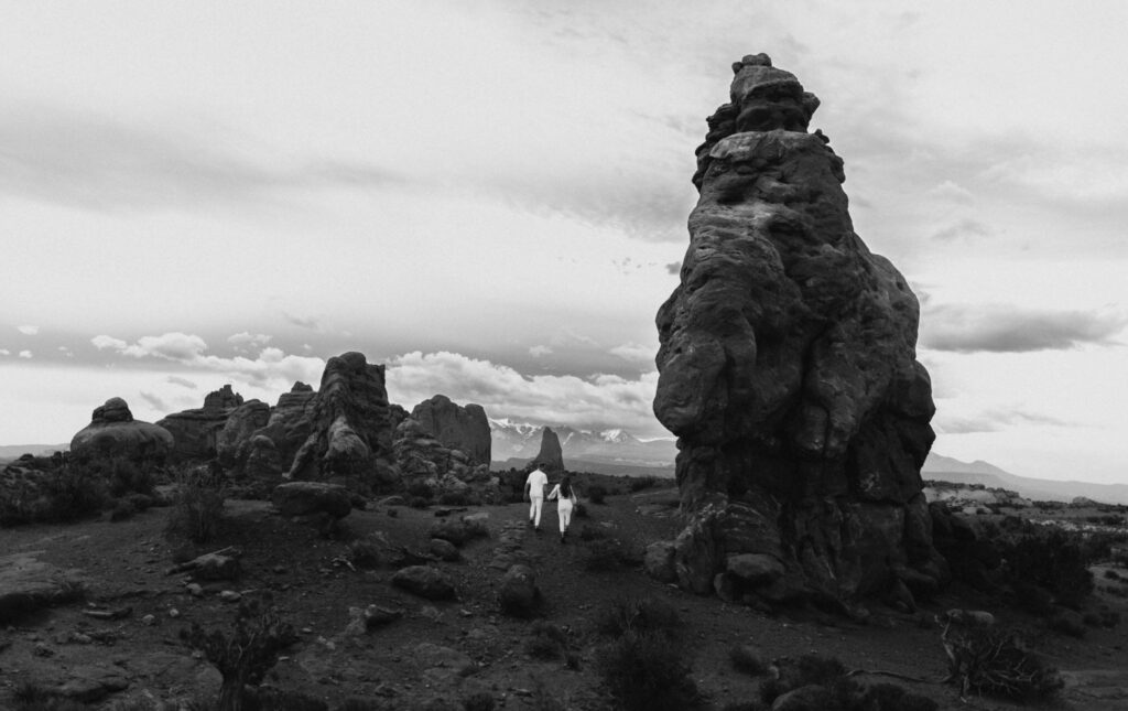 Couple walking through rock formations in Utah for elopement