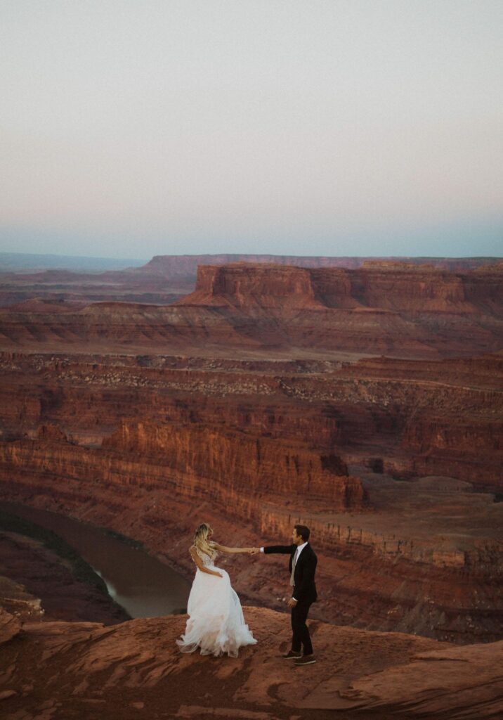 Bride and groom dancing surrounded by rock formation in Utah