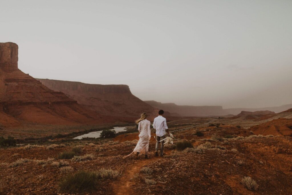 Bride and groom surrounded by red rocks in Utah for elopement