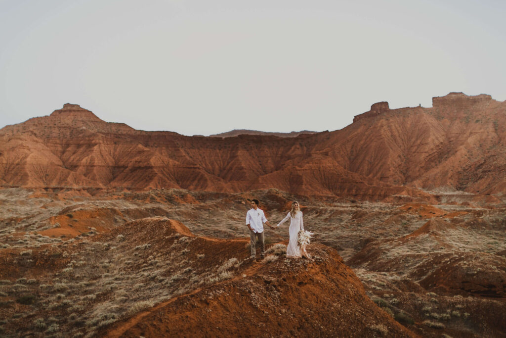 Couple walking at Arches National Park surrounded by red rock formations