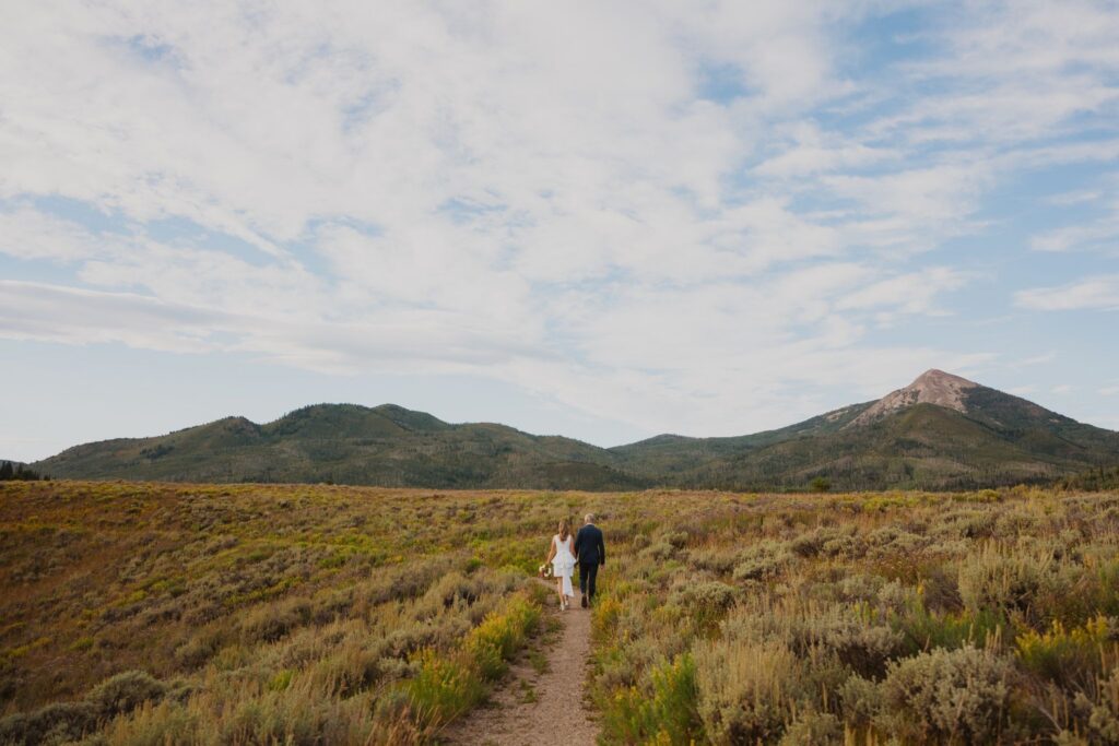 Couple walking away from camera surrounded by scenery in Steamboat Springs