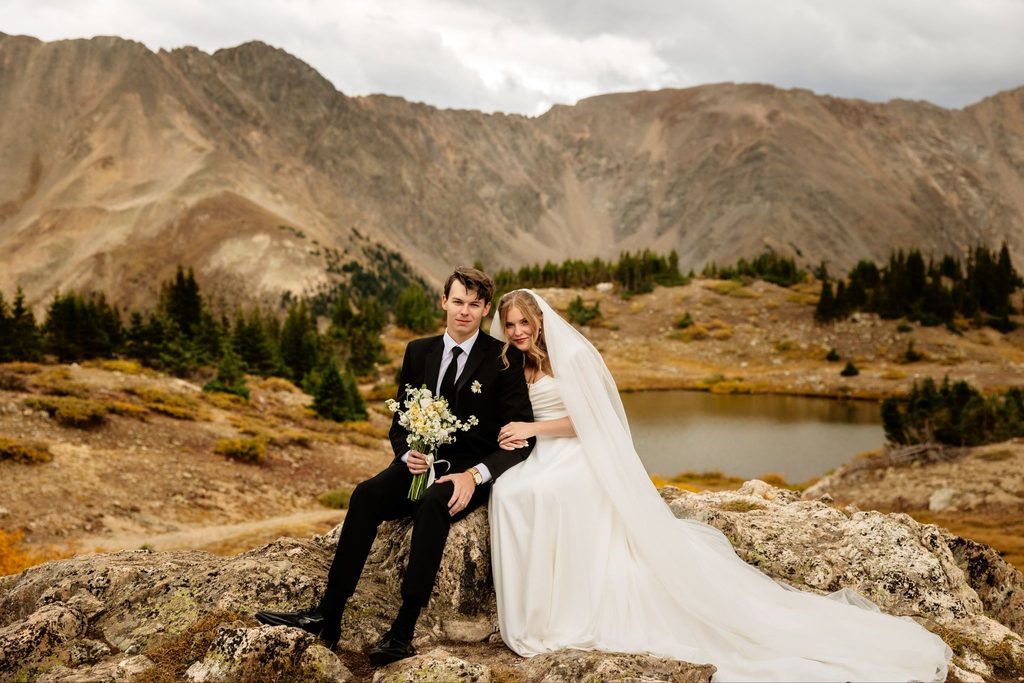 Bride and groom posing and smiling at camera for Loveland Pass elopement